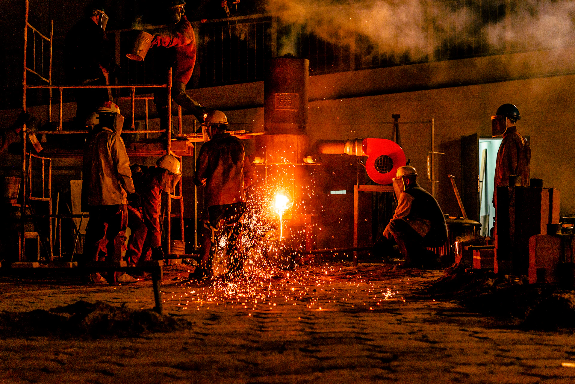 Furnace crew tapping molten metal on the plant floor at night