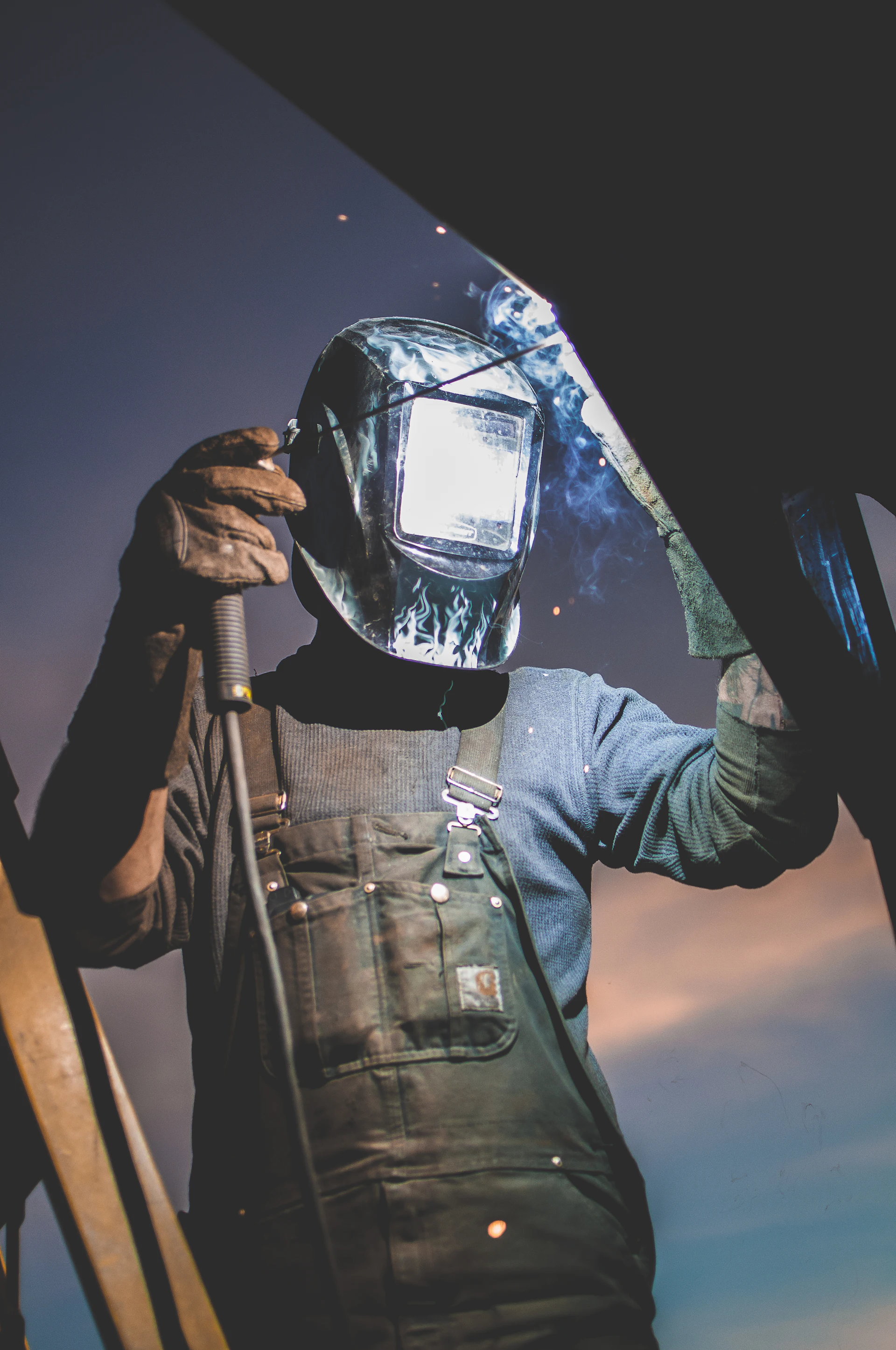 Welder in an auto-darkening helmet